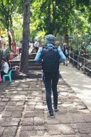 ung attraktiv kvinna turist med ryggsäck kommer till antika Phanom rung tempel i Thailand. foto