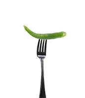 grön chili på gaffel isolerad på vitt foto