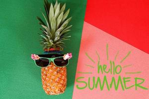 sommar och semester concept.hipster ananas modeaccessoarer och frukter på färgglada och hej sommar ordet bakgrund foto