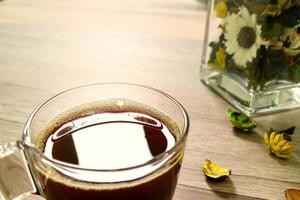 kaffekopp eller te, glasvas blomörter, på träbord, filtereffekt, närbild foto