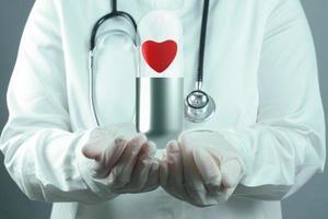 rött hjärta piller inuti kapsel som medicinskt koncept foto