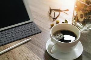 kaffekopp och digital bordsdocka smart tangentbord, vasblomma örter, penna på träbord, filtereffekt foto