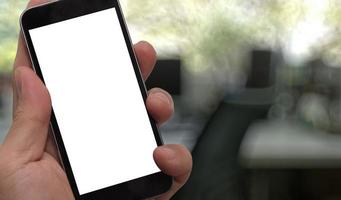 närbild av handen som håller den tomma skärmen på smart telefon med suddig bakgrund som koncept foto