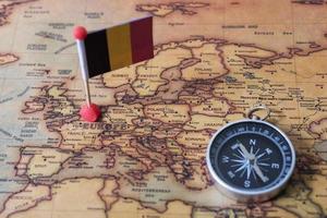Belgiens flagga och kompass på världskartan. foto