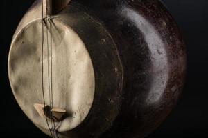 del forntida asiatiska strängade musikinstrument på svart bakgrund med bakgrundsbelysning foto