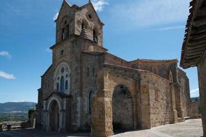 vacker antik kyrka vid frias, merindades, på toppen av staden. klocktorn med klockor. blå himmel, inga människor. burgos, spanien foto