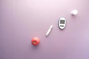 diabetiker mätverktyg, äpple på lila bakgrund foto