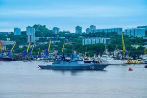 vladivostok, Ryssland - 26 juli 2020 - krigsfartyg på bakgrund av det urbana landskapet. flottans dag. foto