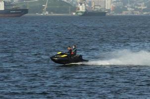 vladivostok, primorsky krai-26 augusti 2018-en man och en kvinna åker på havet på en vattenskoter. foto