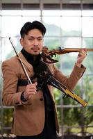 porträtt av asiatisk violinist som håller elektrisk fiol foto
