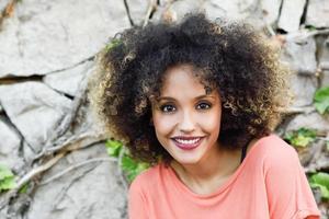 svart kvinna med afro frisyr stående i en stadspark foto