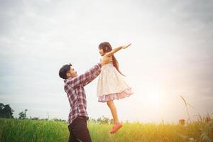 pappa bär sin dotter med natur och solljus, njutning familj. foto