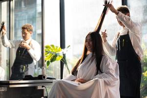 kvinna klient person som har en process för att göra behandling ett hår med frisör i skönhetssalong foto
