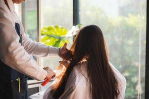 kvinna klient person som har en process för att göra behandling ett hår med frisör i skönhetssalong foto