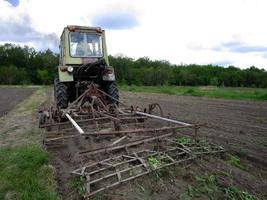 plöjd åker med traktor i brun jord på öppen natur foto