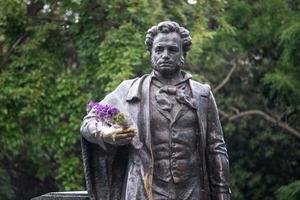 yalta, crimea - 31 maj 2016-Pushkins skulptur på en grön växtbakgrund av träd. foto