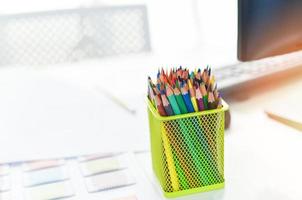 skrivbord på kontoret med dator och färgpennor eller kritor färgade för designerskrivbord - bord arbetsplats affärskontor bakgrund foto