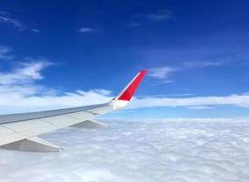 resekoncept, utsikt över moln från fönstret flygplan med mer moln och blå himmel. foto