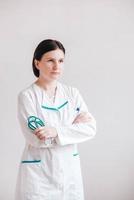 kvinna läkare med ett stetoskop i händerna på en vit bakgrund. kopiera, tomt utrymme för text foto