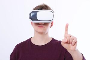 ung man bär virtuell verklighetsglasögon och utrymme för finger isolerad på vit bakgrund. vr koncept och kopieringsutrymme. selektiv fokusering. tom mall skjorta foto