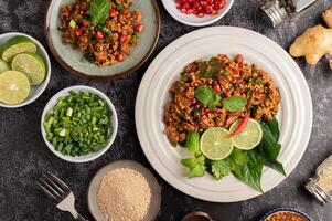 kryddig fläskfärssallad med chiliflakes, lime, hackad salladslök, chili och rostat ris. foto