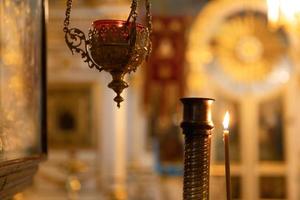 ortodox kyrka. kristendomen. festlig inredning med brinnande ljus och ikon i traditionell ortodox kyrka på påskafton eller jul. religion tro ber symbol. foto