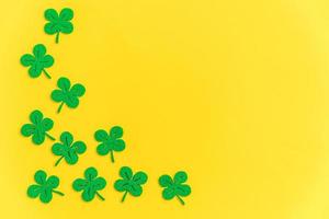 st patricks dag bakgrund. helt enkelt minimal design med grön shamrock. klöver löv isolerad på gul bakgrund. symbol för Irland. lucky fortune wish koncept. platt låg ovanifrån layout kopiera utrymme. foto