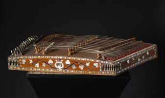 forntida asiatiska strängade musikinstrument på svart bakgrund med bakgrundsbelysning. likheten mellan harpan och psalteriet foto
