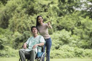 funktionshindrad man i rullstol och flickvän i parken foto