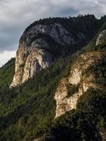 panoramautsikt över alpina ängar och klippor i solnedgångskvällsbelysning foto