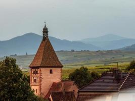 Alsace landskap med spiran av klocktornet i en liten by foto