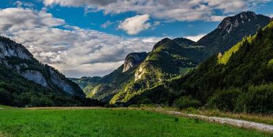 panoramautsikt över alpina ängar och klippor i solnedgångskvällsbelysning foto