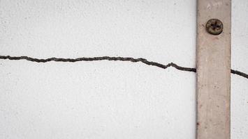 sprickor på väggen. sprickan i cementväggen vid fönsterbrädan, orsakad av markens sättning, vilket orsakar en slits i sned vinkel. foto
