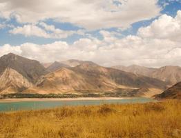 landskap med sjö- och bergsutsikt. uzbekistan, charvakreservoar. Centralasiens natur foto