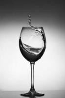 vitt vin stänk på grå bakgrund. siluett av ett glas. selektiv fokusering foto