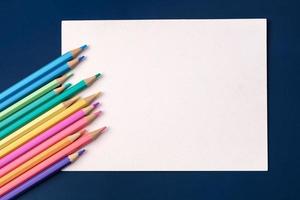 ovanifrån papperskort med färg pastell penna på marinblå bordsbakgrund foto