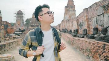 resenär asiatisk man tillbringar semesterresa i ayutthaya, thailand, backpackerman njuter av sin resa vid ett fantastiskt landmärke i traditionell stad. livsstil män reser semester koncept. foto