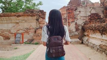 resenär asiatisk kvinna tillbringar semesterresa i ayutthaya, thailand, japansk backpacker-kvinna, njut av sin resa vid ett fantastiskt landmärke i en traditionell stad. livsstil kvinnor reser semester koncept. foto