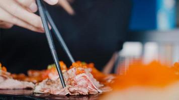 asiatisk kvinna som äter sushi på japansk restaurang, ung kvinna som håller ätpinnar och äter wagyu-biffsushi vid lunchtid på sommaren. livsstil kvinnor äter traditionell mat koncept. foto