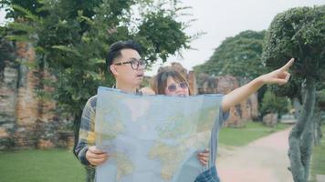 resande asiatiskt par riktning och tittar på platskartan medan du tillbringar semesterresan i ayutthaya, thailand, backpacker-par njuter av resan i traditionell stad. livsstil par resor koncept. foto