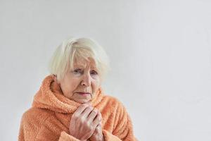 äldre sjuk kvinna fryser kallt hemma. hälsovård, kris, gammalhetskoncept foto