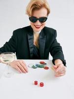 mogen snygg kvinna i svart smoking och solglasögon glad att vinna i kasinot. spel, mode, hobby koncept. foto