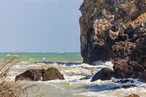 vågor och starka havsvindar svepte över stenar och stim. vågor och havsbrisar slår mot klippor och stränder. foto