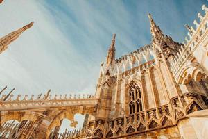 taket på katedralen i milano duomo di milano med gotiska spiror och statyer i vit marmor. topp turistattraktion på piazza i Milano, Lombardiet, Italien. vidvinkelvy av gammal gotisk arkitektur och konst. foto