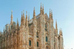 berömda kyrkan milano katedral duomo di milano med gotiska spiror och vita marmorstatyer. topp turistattraktion på piazza i milano lombardia, Italien. vidvinkelvy av gammal gotisk arkitektur och konst foto