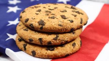 patriotiska kakor. tre rundade traditionella chokladkakor på bakgrunden av USA:s flagga. läckra söta bakverk, dessert. amerikas favoritgodis. foto