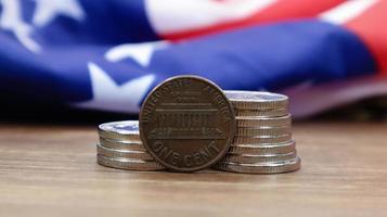 ett 1 cent amerikanskt dollarmynt ligger på den amerikanska flaggan. valutan är en cent över USA:s flagga. foto