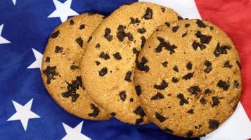 patriotiska kakor. tre rundade traditionella chokladkakor på bakgrunden av USA:s flagga. läckra söta bakverk, dessert. amerikas favoritgodis. foto