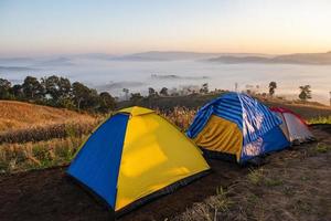 camping tält område på berg, turist tält camping med dimma dimma landskap soluppgång vacker på vintern utsikt utomhus resor. foto