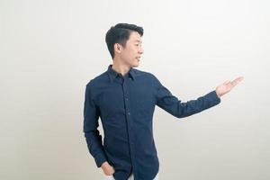 asiatisk man med hand som pekar eller presenterar på vit bakgrund foto